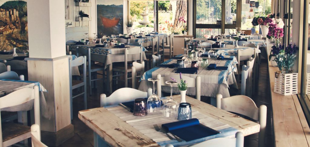 Interno di un ristorante con tavoli apparecchiati.