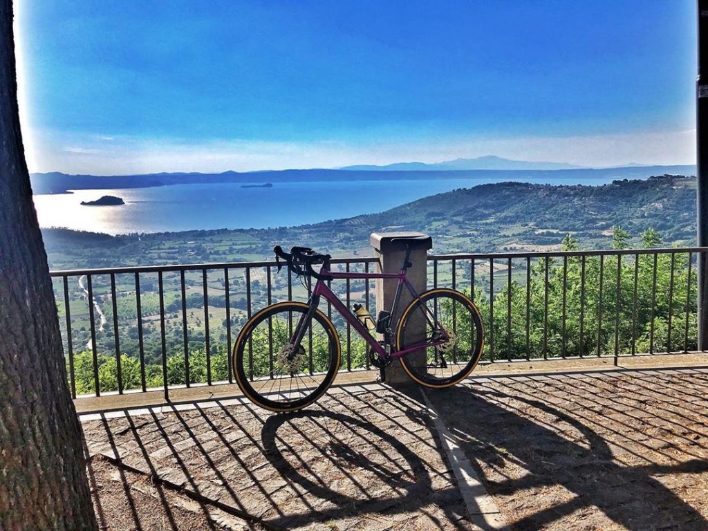 Bicicletta appoggiata a ringhiera con vista lago.