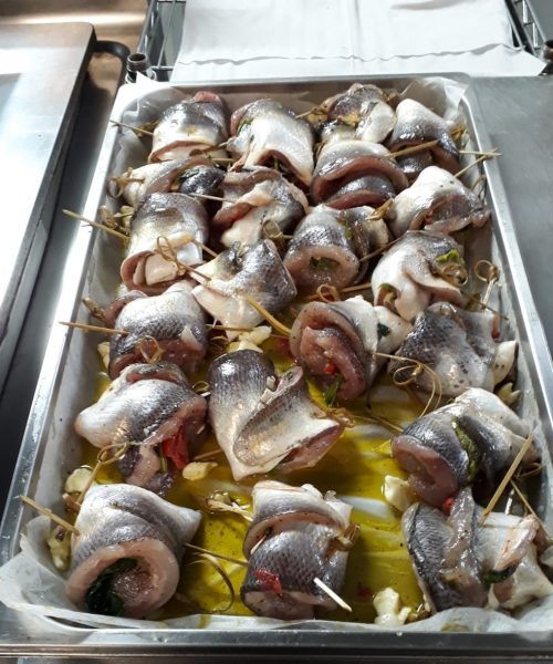 Involtini di pesce crudo su teglia da forno.