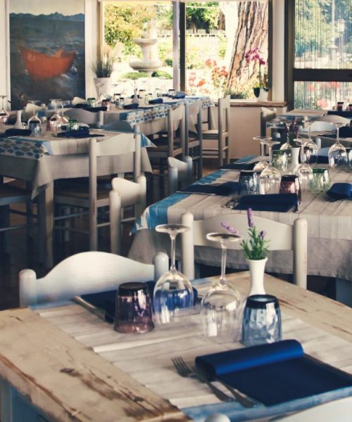 Interno di un ristorante con tavoli apparecchiati.