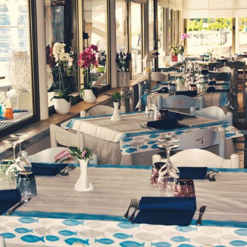 Tavoli apparecchiati in un ristorante con fiori e tovaglie.