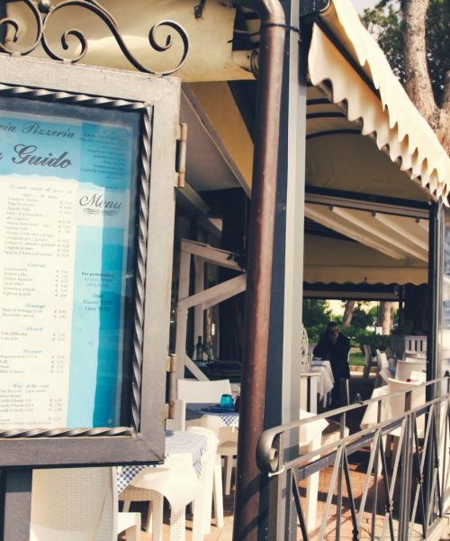 Menu esposto all'esterno di un ristorante con veranda.
