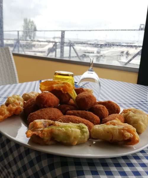 Piatto di fritti su tavolo con tovaglia a quadri.