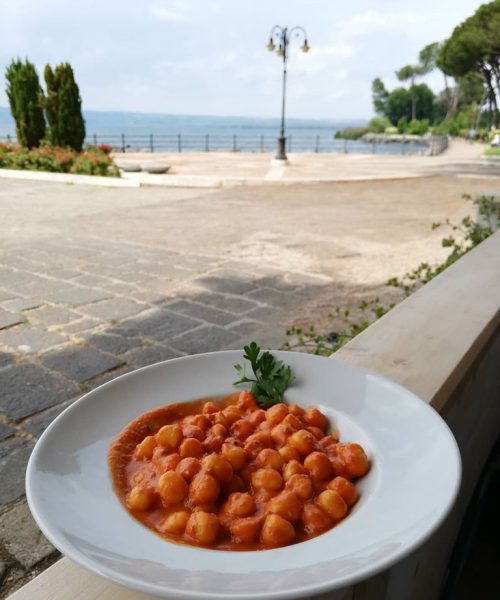Piatto di gnocchi al sugo con vista sul lago.