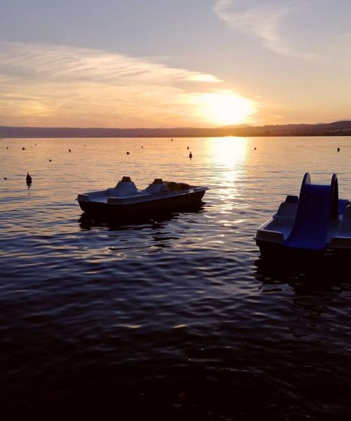 Due pedalò sul lago al tramonto.